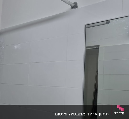 מראה עם מסגרת מתכת בחדר אמבטיה